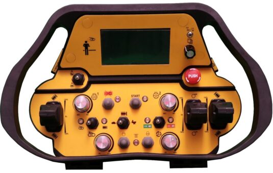 In quest'immagine si vede un macchinario di colore giallo e nero con dei bottoni neri e rossi